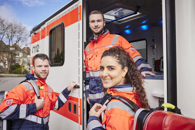 Drei Rettungskräfte vor einem RTW